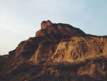 Low angle view of rock formation against sky