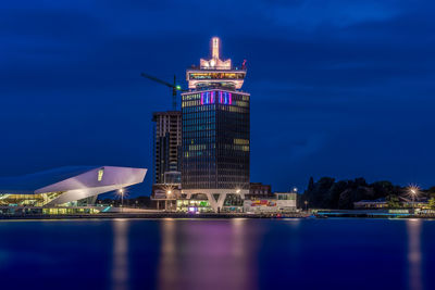 Illuminated a dam toren by river at night