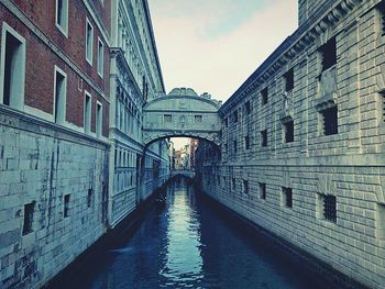 Walkway amidst city against sky