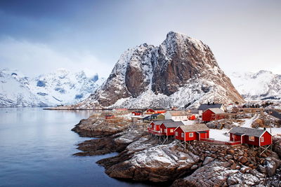 Traditional building by snowcapped mountains against sky