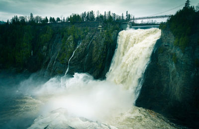 Scenic view of waterfall against sky