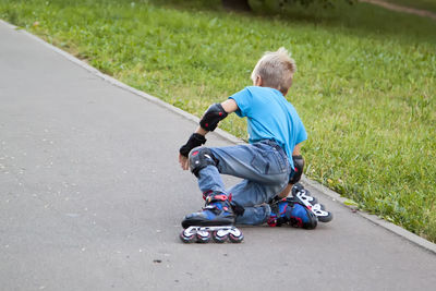 Rear view of boy wearing skates on street