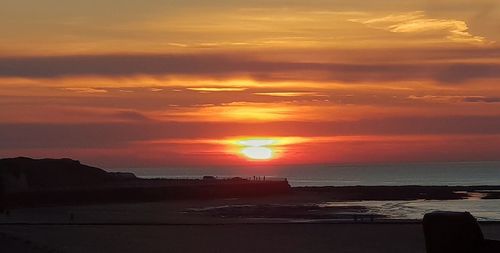 Scenic view of sea against orange sky