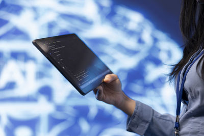 Midsection of woman using digital tablet