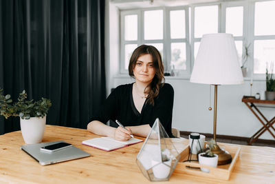 Business girl freelancer in casual clothes works using wireless technology in the home office