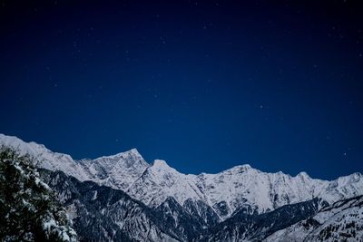 Beautiful mountain covered in snow with stars above it 