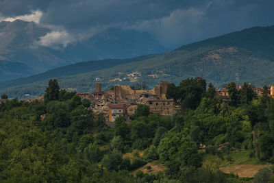 Scenic view of trees and buildings against sky