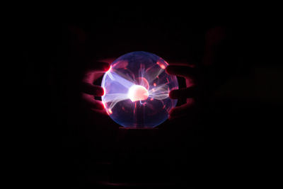 Close-up of illuminated lighting equipment against black background