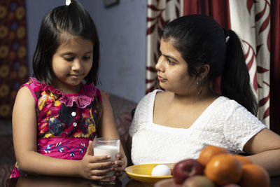 Young woman sitting with vegetables