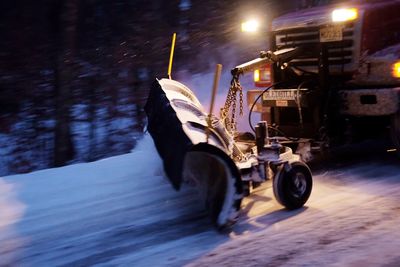 Close-up of snow on illuminated car at night