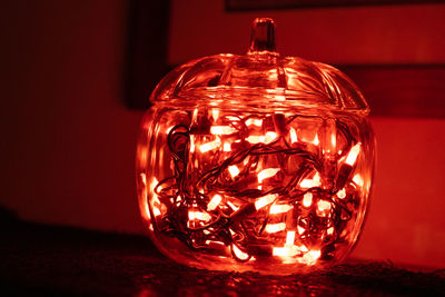 Close-up of illuminated light bulb on table