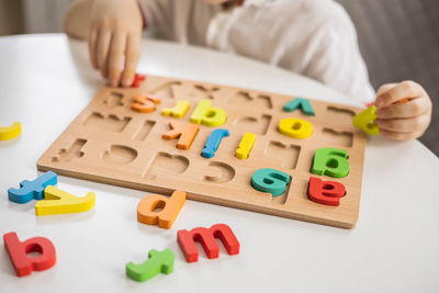 Midsection of man playing with toy blocks on table