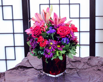Close-up of pink flower pot on window
