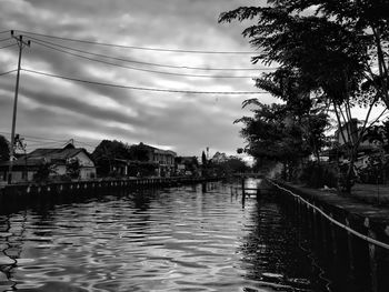 River amidst houses and buildings against sky