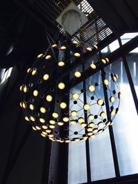 Low angle view of illuminated light bulbs hanging on ceiling