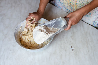 Cropped hand of person preparing food on table