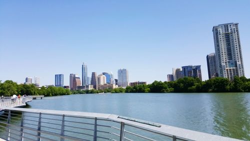 View of city by river against clear sky