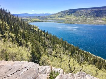Scenic view of lake and mountains against blue sky