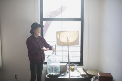 A young woman filling a tank with coins