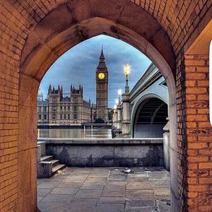 View of historic building against sky seen through arch