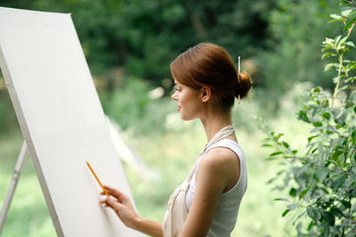 Midsection of woman with arms raised standing outdoors