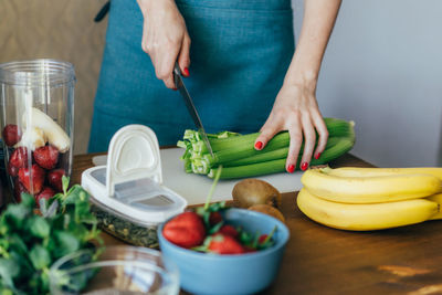 Midsection of woman cutting vegetable