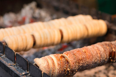 Chimney cake baking on a spit over charcoal fire