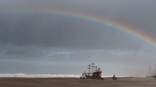 Scenic view of rainbow over sea against sky