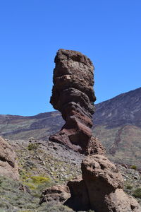 Low angle view of stone wall against clear blue sky
