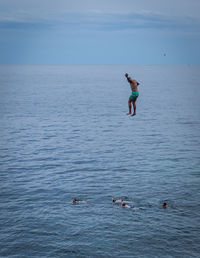 Man surfing in sea against sky