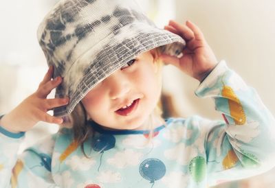 Portrait of cute baby girl holding hat