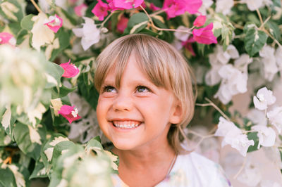 Portrait of face of a candid little happy smiling five year old blonde kid boy with green eyes