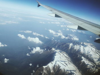 Aerial view of aircraft wing over landscape against sky