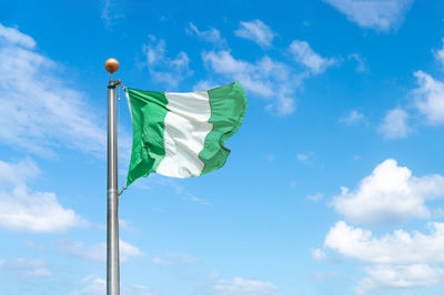 Low angle view of flag against blue sky