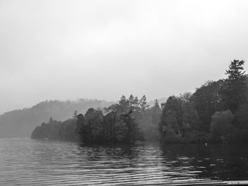 Scenic view of lake against sky during foggy weather