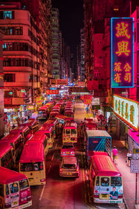 Illuminated street amidst buildings in city at night