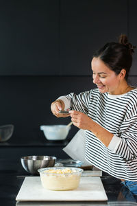 Young woman having food at home