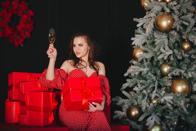 Young woman holding christmas tree in box