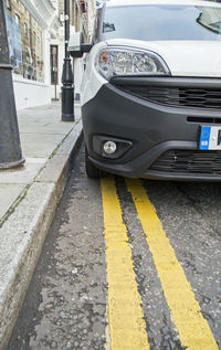 Close-up of yellow car on street