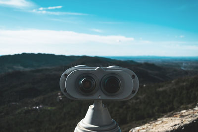 Close-up of coin-operated binoculars against sky