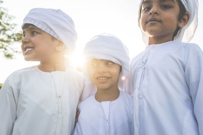 Low angle view of cute boys standing outdoors