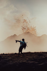 Side view of man standing against sky during sunset