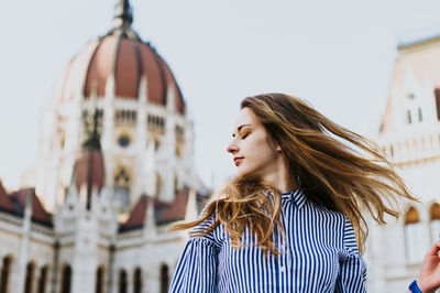 Woman standing against historic building in city