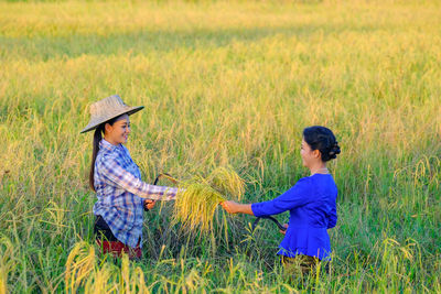 Side view of man and woman standing on field