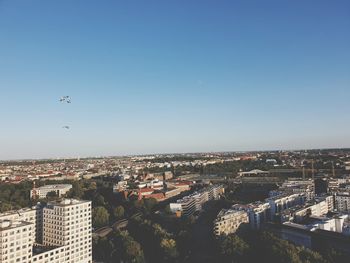 Aerial view of buildings in city against sky