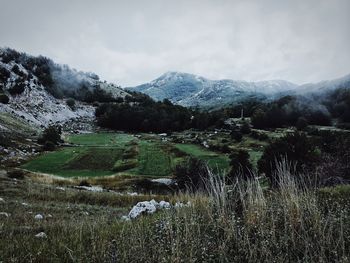 Scenic view of lake by mountains against sky