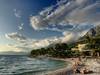 People on beach against sky