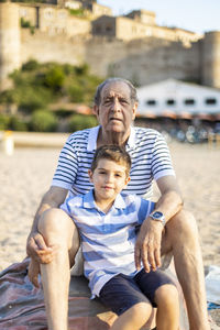 Portrait of grandfather and grandson at beach