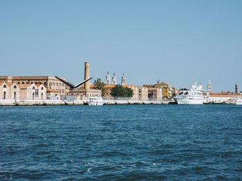 Scenic view of sea by buildings against clear sky