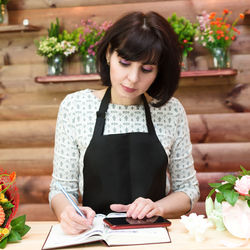 Young woman holding flowers on table